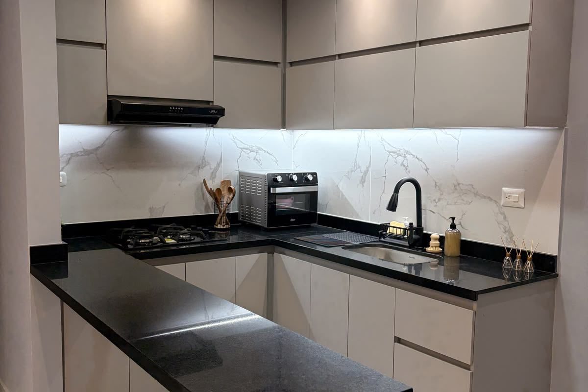 Cocina en L con barra de granito — después